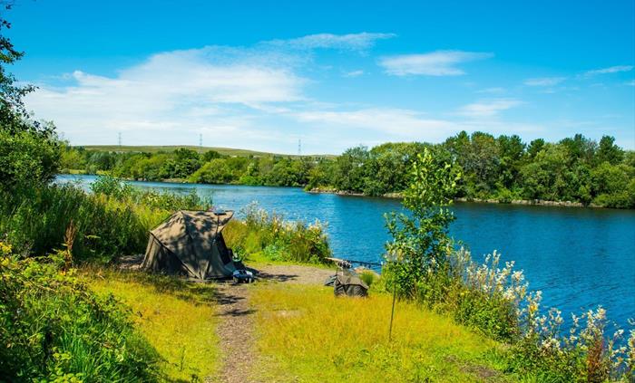 Fishing from the banks of the lake at Parc Bryn Bach.
